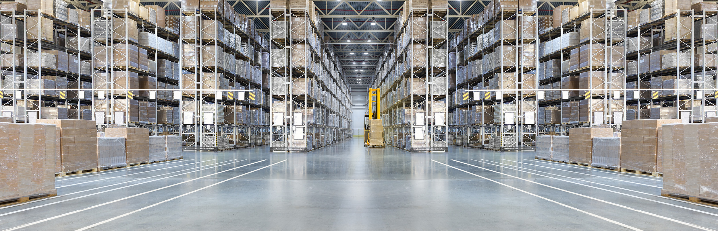Organized warehouse with several rows of pallet racks stacked with boxes