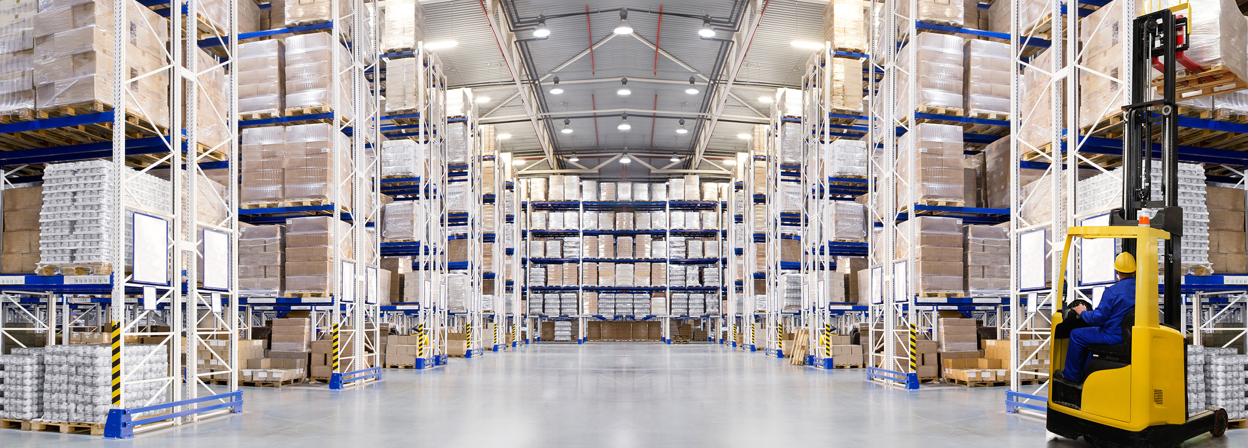 Man driving forklift through a warehouse