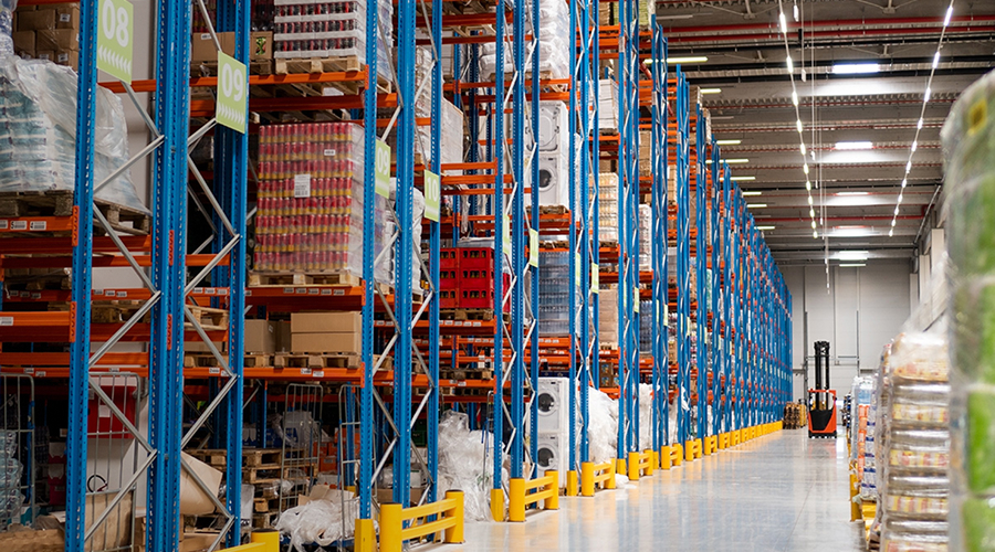 Organized warehouse with several rows of pallet racks stacked with boxes