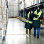 People with clipboards walking in warehouse
